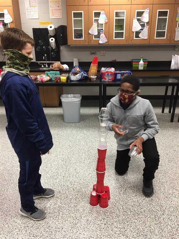 Students play a cup-stacking game